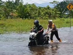 Polisi Bantu Pengendara Motor Terobos Banjir di Bunta